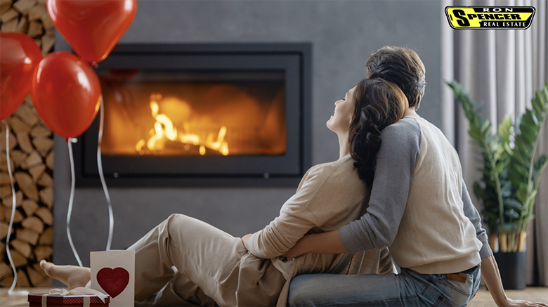 Couple in front of a fireplace with red balloons