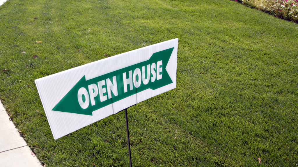 Green grass yard with an open house sign with a green arrow pointing to the left