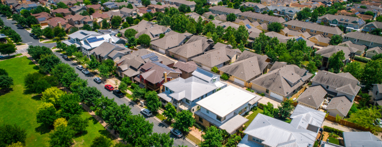 Aerial view of a housing development with green grass and newer homes