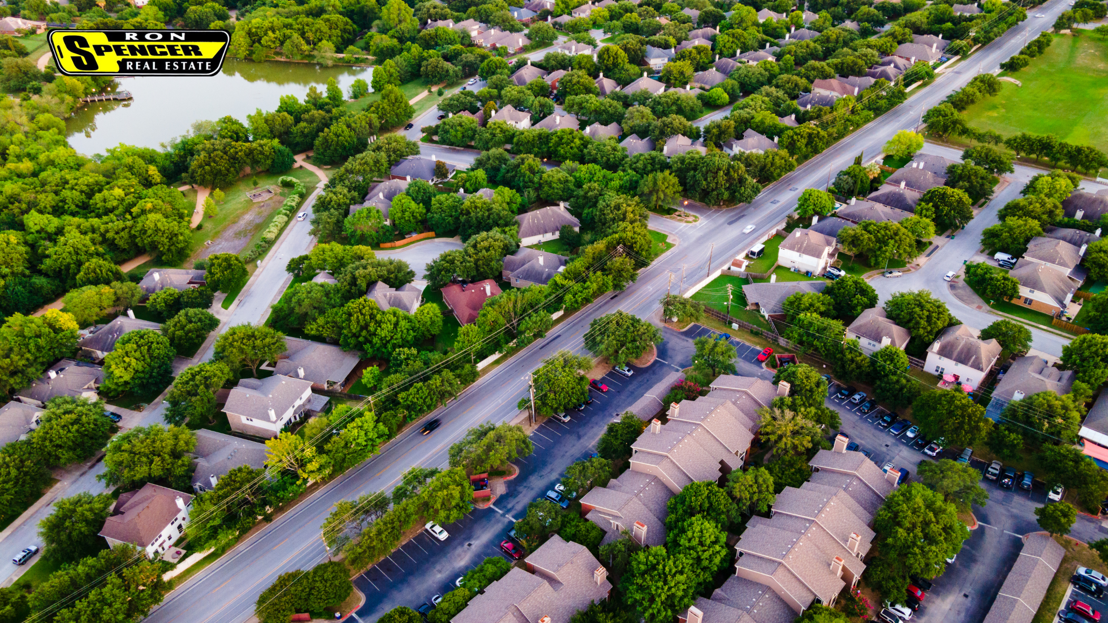 Overhead look at a neighborhood with green trees and roadways