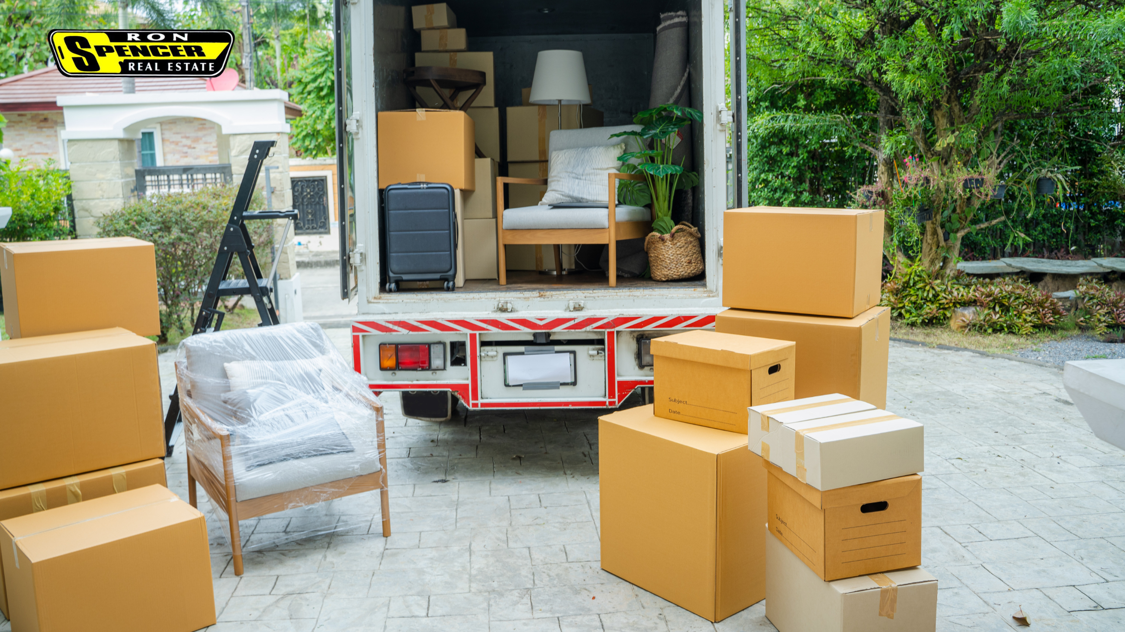 stack of moving boxes in the driveway being loaded on a box truck