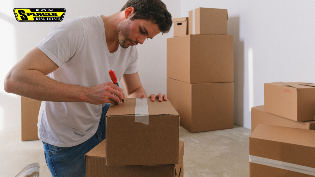man writing labels out on moving boxes