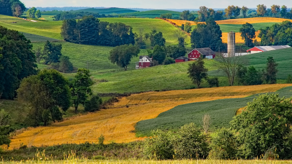 a depiction of rural Ohio with farmland, red barns, green trees, etc.