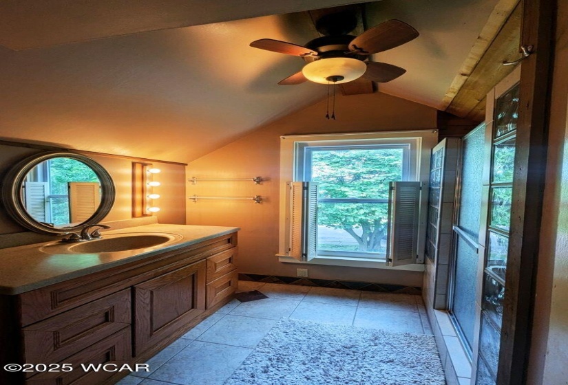 Full bathroom suite with vanity and tiled step-in shower.